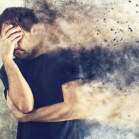 Depressed Man with Problems holding hand over his Face and Crying