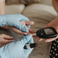 Pricking finger on blood glucose meter